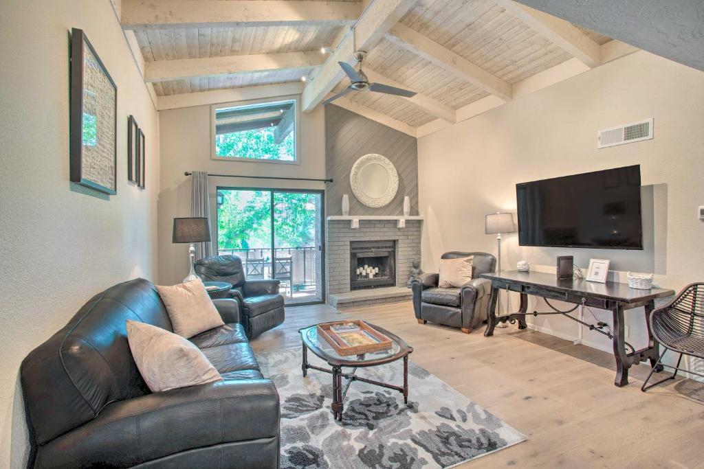 a living room with leather furniture and a tv at Bright Sedona Condo Resort-Style Amenities! in Sedona