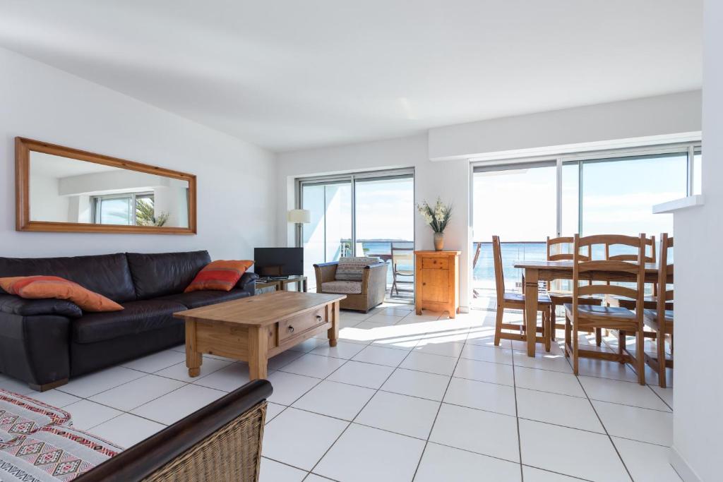 un salon avec un canapé et une table dans l'établissement Bright two bedroomed apartment on the beach in Cannes with huge terrace with fabulous sea views - 2001, à Cannes
