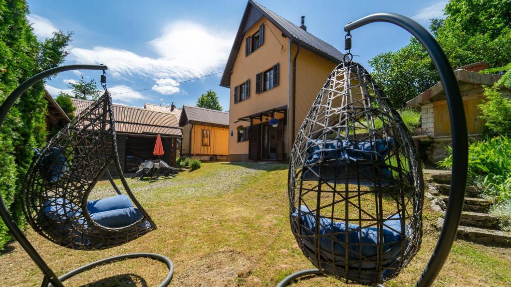 Deux balançoires dans une cour à côté d'une maison dans l'établissement Karolina, à Fužine