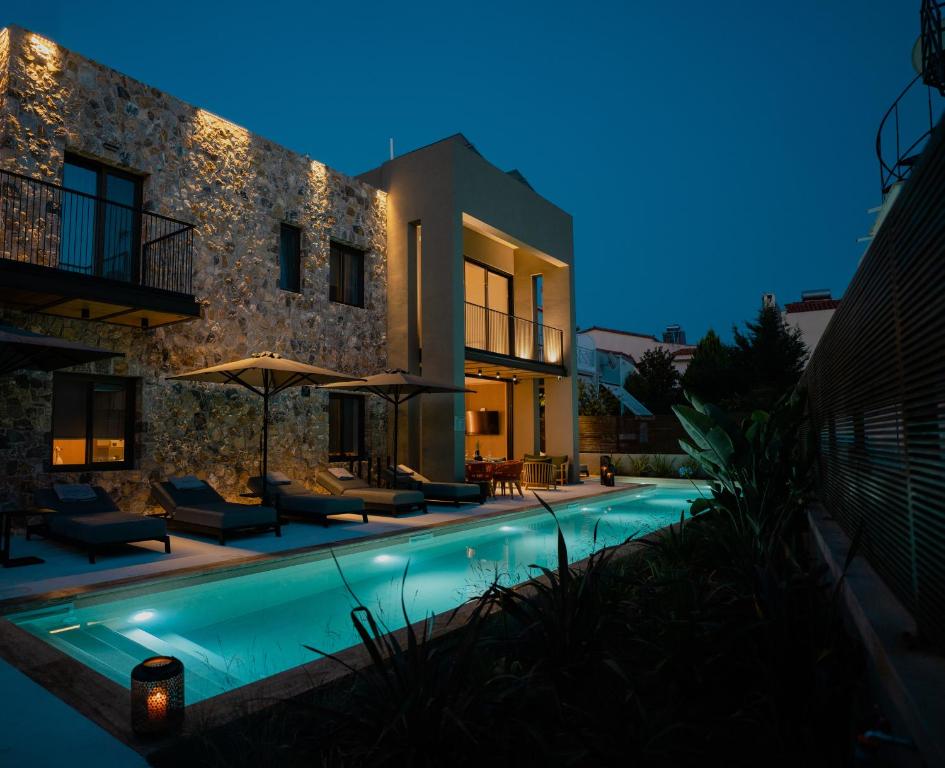 a villa with a swimming pool at night at Capital Luxury Suites in Nafplio