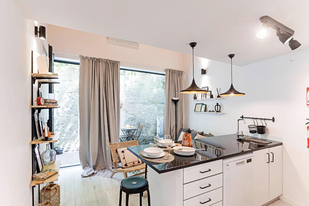 a kitchen with white cabinets and a large window at Vila Terra Luxury Apartments I in Vila Nova de Gaia