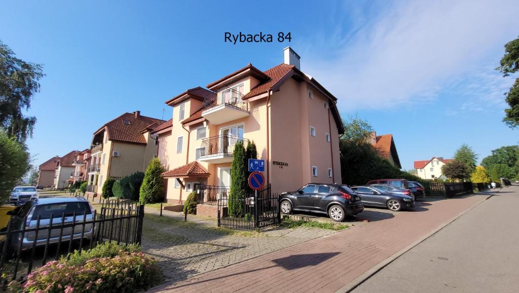 a group of cars parked in front of a house at Apartament Rybacka 84m1 in Krynica Morska