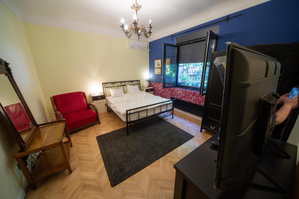 ein Wohnzimmer mit einem Sofa und einem TV in der Unterkunft Cosy studio apartment in a heart of the Belgrade in Belgrad