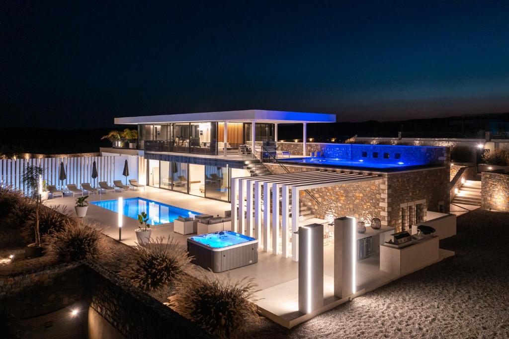 a building with a swimming pool at night at amara luxury villas in Lakhania