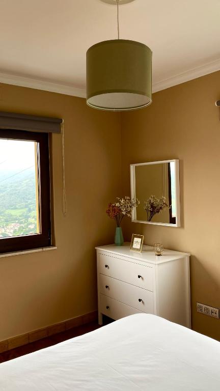 a bedroom with a bed and a mirror and a dresser at La Pedrosa in Fontanina