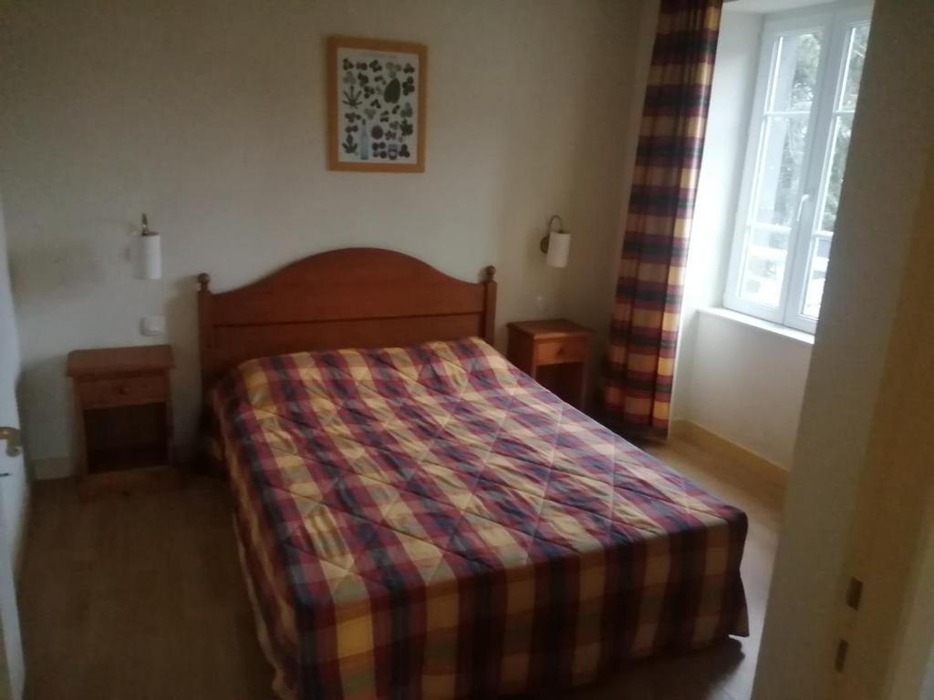 - une chambre dotée d'un lit avec une couverture tressée dans l'établissement Appartement de standing - La Bourboule, à La Bourboule