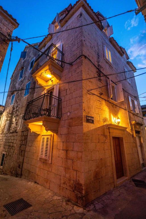 an old stone building with balconies on a street at Old town Makarska apartments - central square in Makarska
