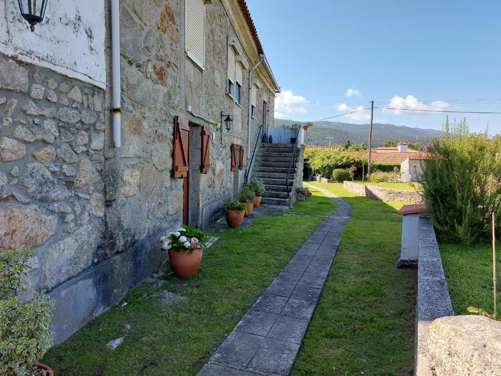 ein Steingebäude mit Topfpflanzen neben einem Gebäude in der Unterkunft Quinta da Ponte in Viana do Castelo