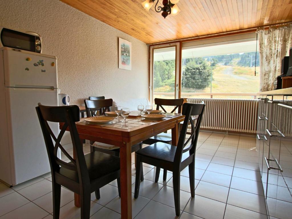 uma sala de jantar com uma mesa e cadeiras e um frigorífico em Appartement Chamrousse, 2 pièces, 4 personnes - FR-1-549-69 em Chamrousse