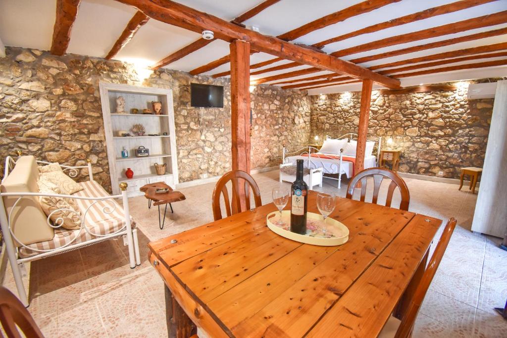 una mesa de madera en una habitación con una pared de piedra en The Stone suite en Moraitika