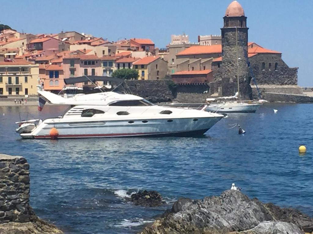 a white boat in the water near a city at SAS L étoile de mer in Argelès-sur-Mer