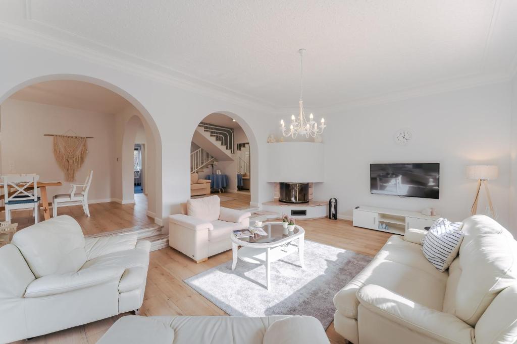 a living room with white furniture and a table at Willa Laguna in Kołobrzeg