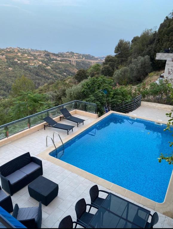 une grande piscine avec des chaises longues dans l'établissement Spacieuse Villa Niçoise au calme avec piscine, à Nice