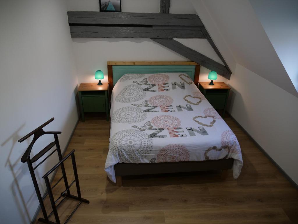 a attic bedroom with a bed and two night stands at Le grenier des hirondelles Gîte appartement au coeur de la route des vins d'Alsace in Rouffach