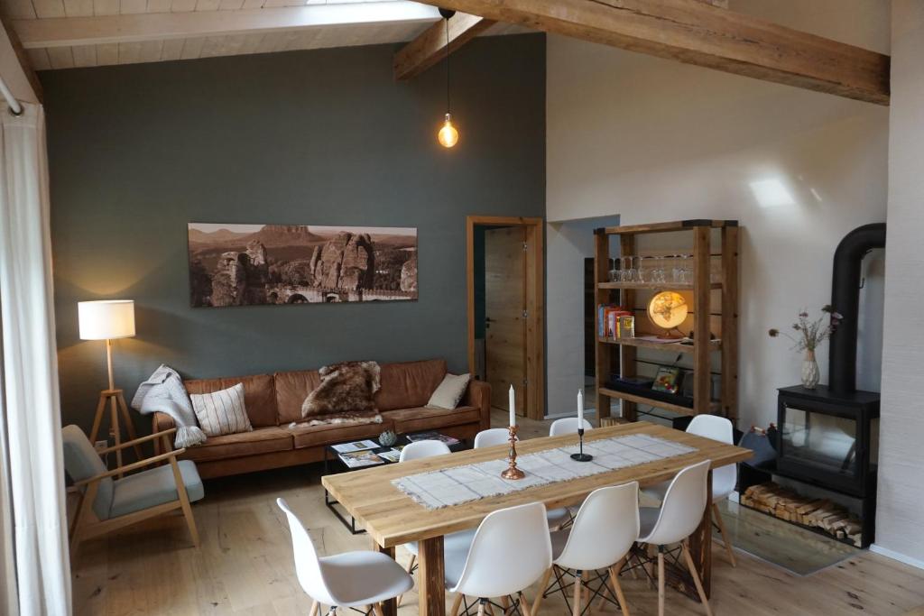 ein Wohnzimmer mit einem Holztisch und weißen Stühlen in der Unterkunft Alte Brennerei Schloss Zehista OG Akelei in Pirna