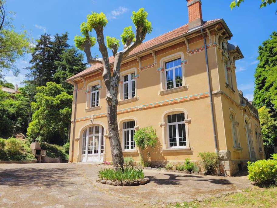 een geel huis met een boom ervoor bij Villa Benjamine - Parc Haut Languedoc in Lamalou-les-Bains