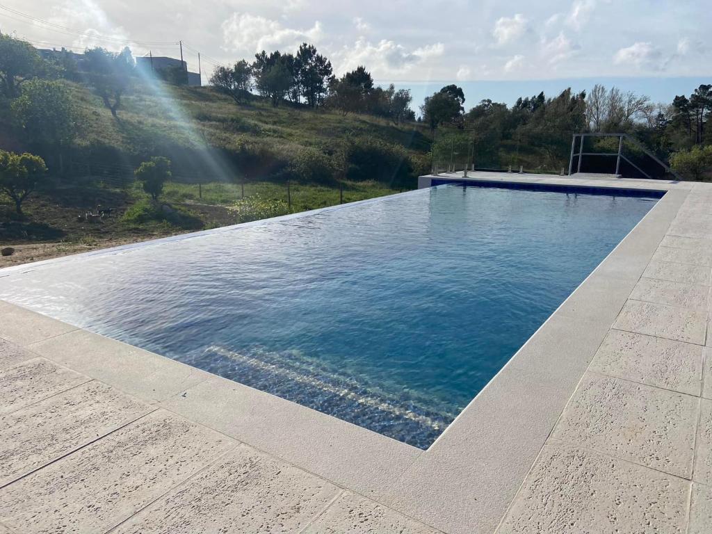 a large swimming pool with blue water at Zambujal Suites in Sesimbra