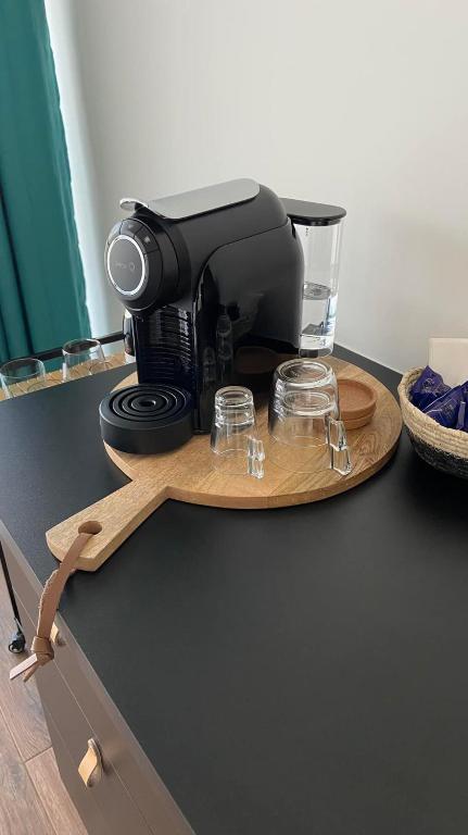 a black coffee maker on a wooden tray with glasses at Zambujal Suites in Sesimbra