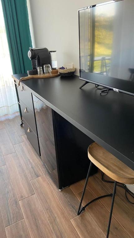 a black desk with a monitor and a chair at Zambujal Suites in Sesimbra