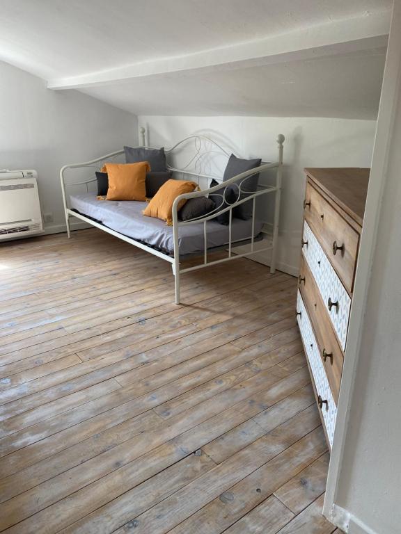 um quarto com uma cama e piso em madeira em Logement avec jardin privé confortablement équipé em Bagard