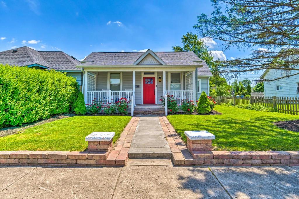 una casa con una puerta roja y un patio en Family-Friendly Home Near Noblesville Square! en Noblesville