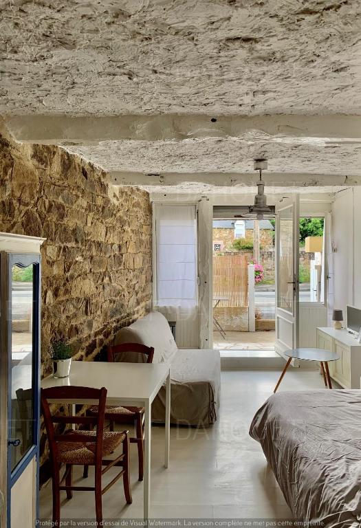 une chambre avec un lit et un mur en pierre dans l'établissement Joli studio avec terrasse à deux pas de la plage, à Pléneuf-Val-André