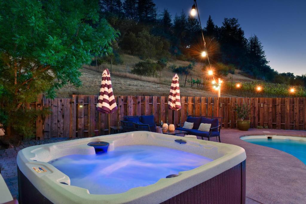 una bañera de hidromasaje en un patio junto a una piscina en Calistoga Vineyard Getaway, en Calistoga