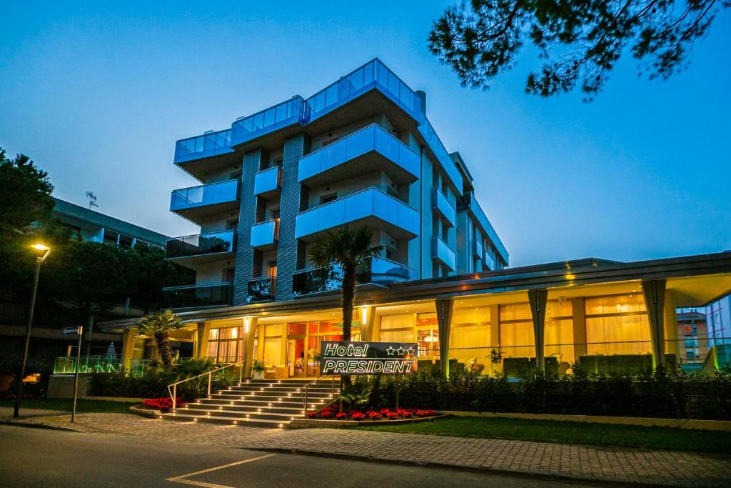 un edificio azul con un cartel delante en Hotel President, en Bibione