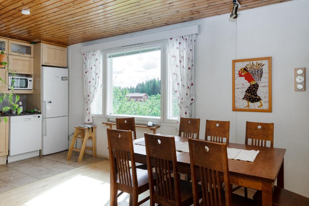 d'une cuisine et d'une salle à manger avec une table et une fenêtre. dans l'établissement Mummon mökki - Granny´s cottage, à Suonenjoki