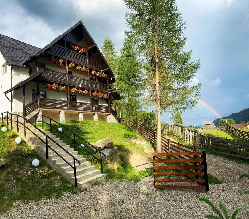 a house with a balcony and a staircase in front of it at Roua Bucovinei in Sadova