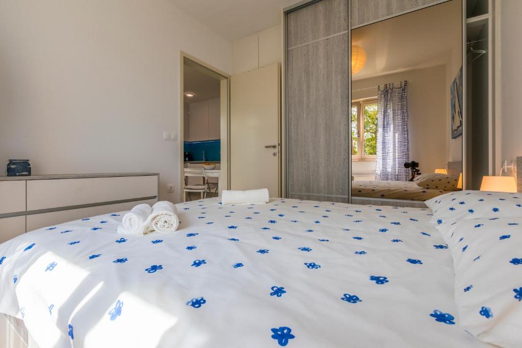 ein Schlafzimmer mit einem großen weißen Bett mit blauen Blumen darauf in der Unterkunft MB APARTMANI in Crikvenica