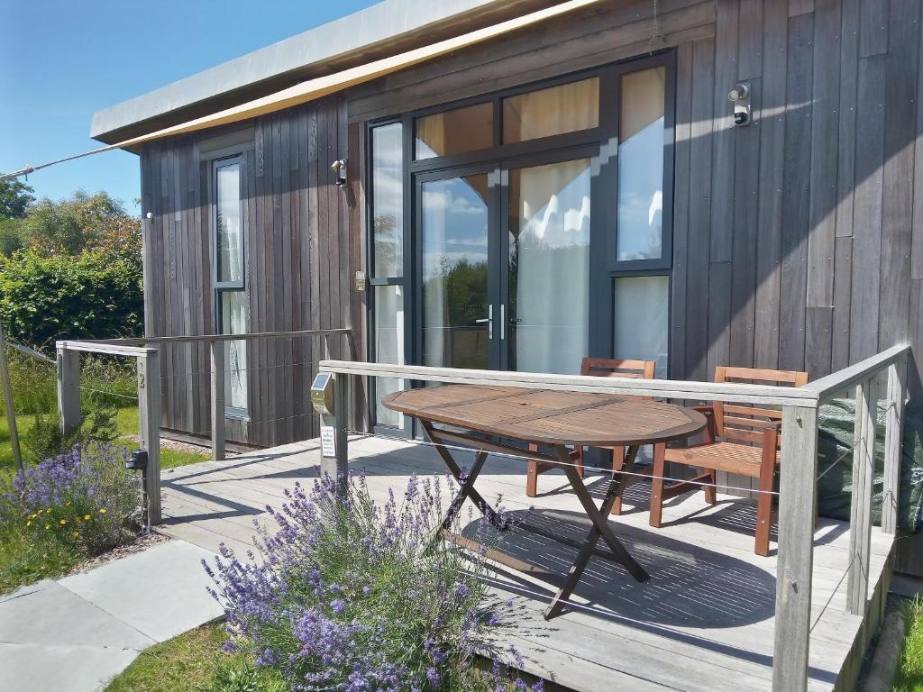 a wooden deck with a table and chairs on a house at The Gallery Lodges in Braunton
