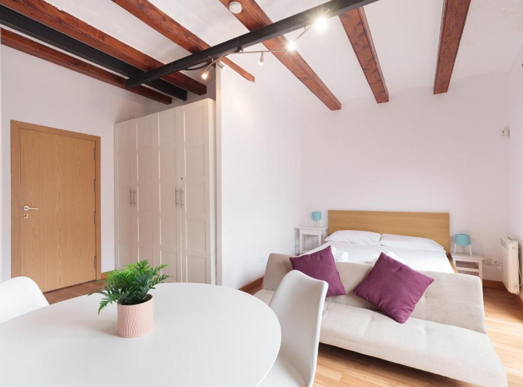 バルセロナにあるGuadiana · Apartment 2x1, near Sants stationの白いベッドルーム(ベッド1台、ソファ付)