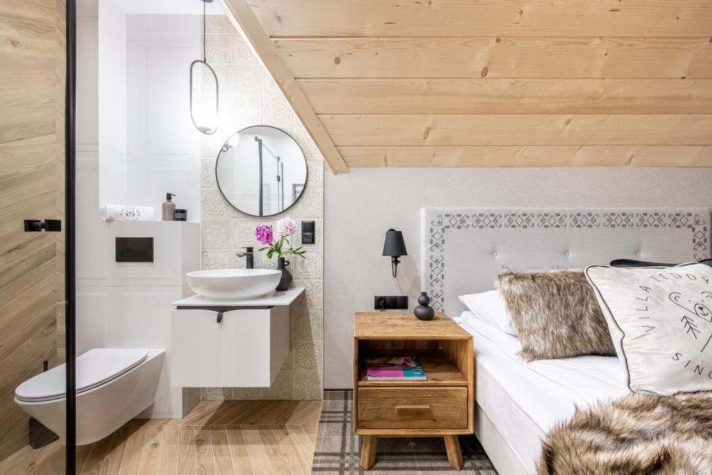 a bathroom with a bed and a sink and a mirror at VILLA TEDDY BEAR Zakopane in Zakopane