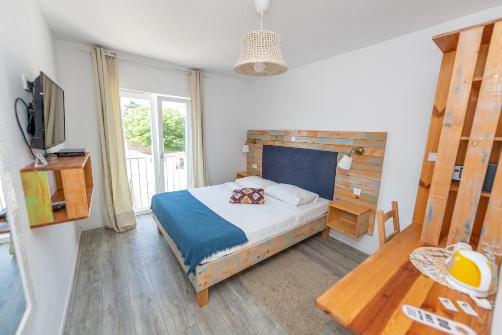 1 dormitorio con cama, mesa y TV en Boho House, en Pakoštane
