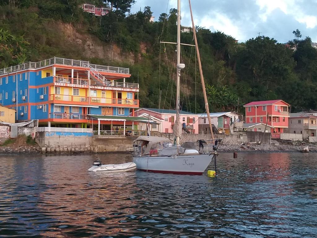 un velero en el agua frente a un edificio en Sea World Vacation Home, en Roseau