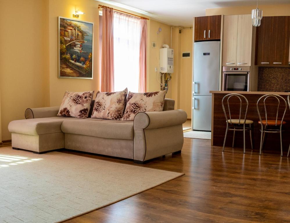 a living room with a couch and a kitchen at Nema s Apartment 1 in Braşov