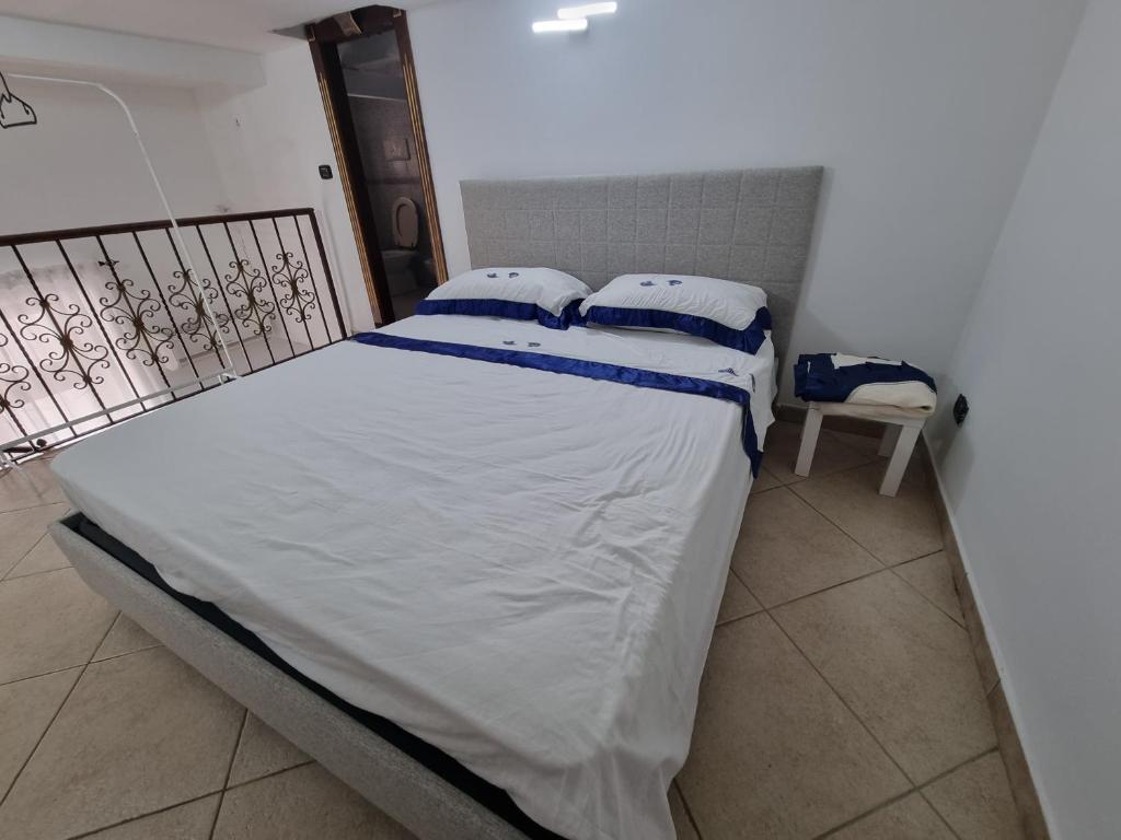 a bed with white sheets and blue pillows on it at B&b casa (le porte di napoli) in Naples