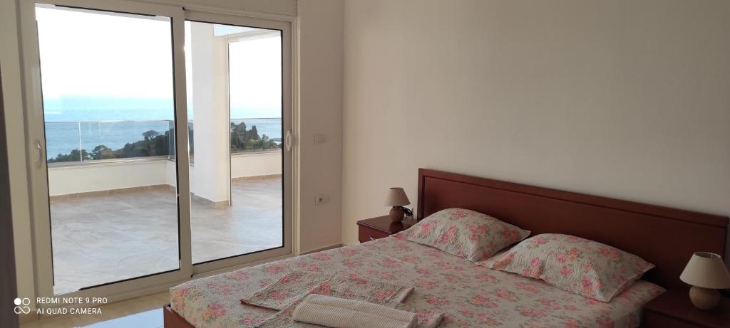 Un dormitorio con una cama y una ventana grande. en IdealHouse Apartments, en Ulcinj