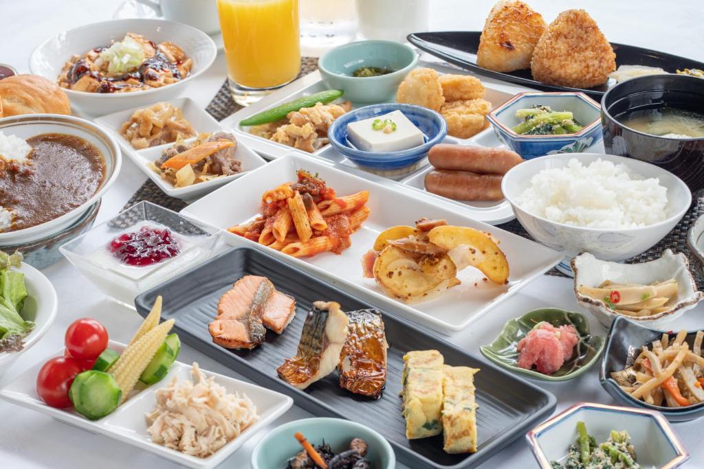 a table with many different types of food in trays at Hotel New Carina in Morioka