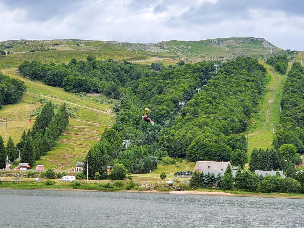 une personne sur un fil au-dessus d'un plan d'eau dans l'établissement Bel appartement spacieux 44m² à SUPER BESSE pour 6 personnes, à Super-Besse