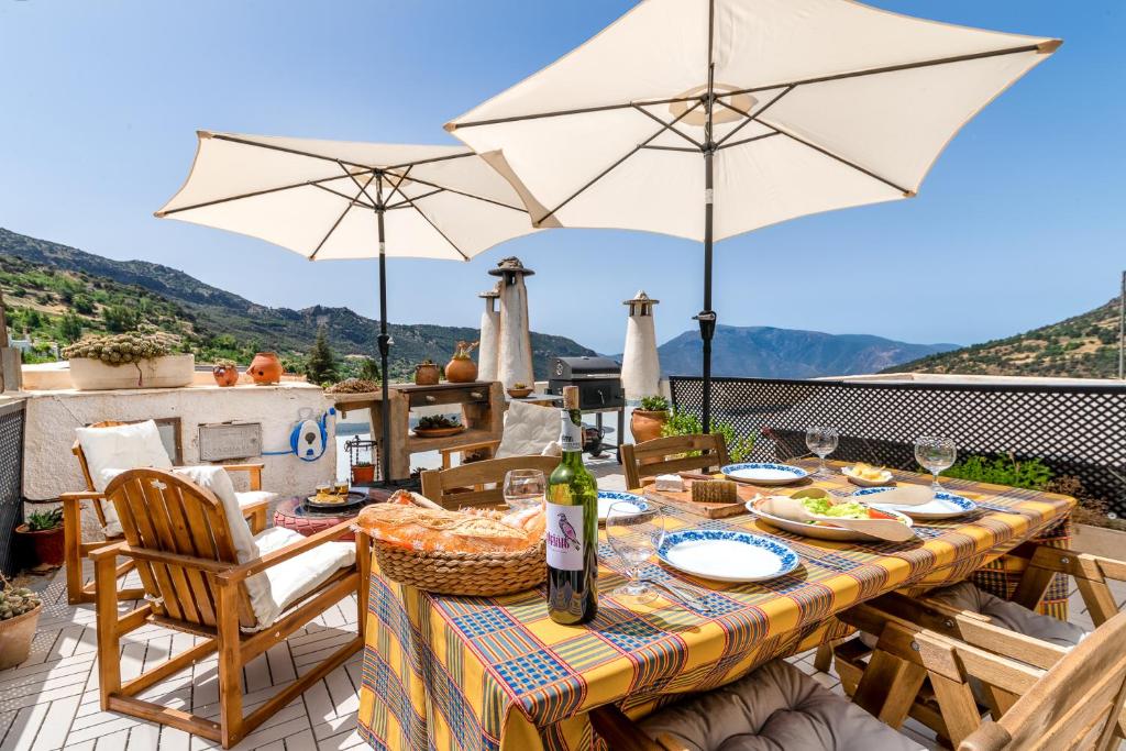 a table with an umbrella on top of a patio at La Casa de Antonio in Capileira