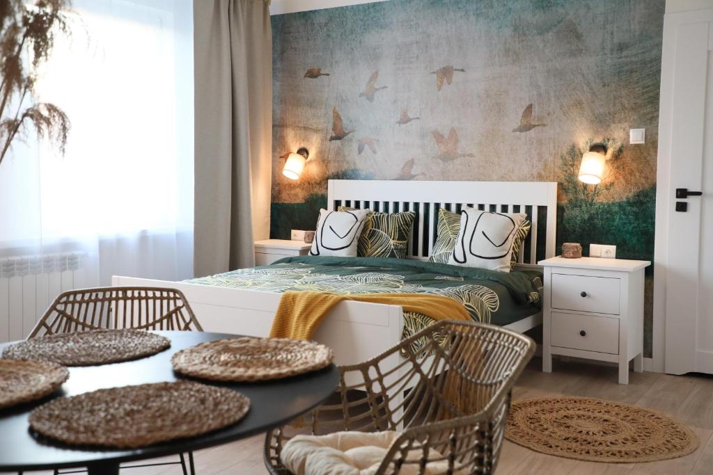 a bedroom with a bed and a table and chairs at Złota#208 in Złota