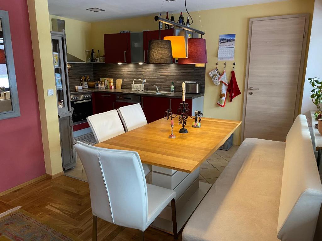 cocina con mesa de madera y sillas blancas en Ferienwohnung Erfurt Marbacher Höhe en Erfurt