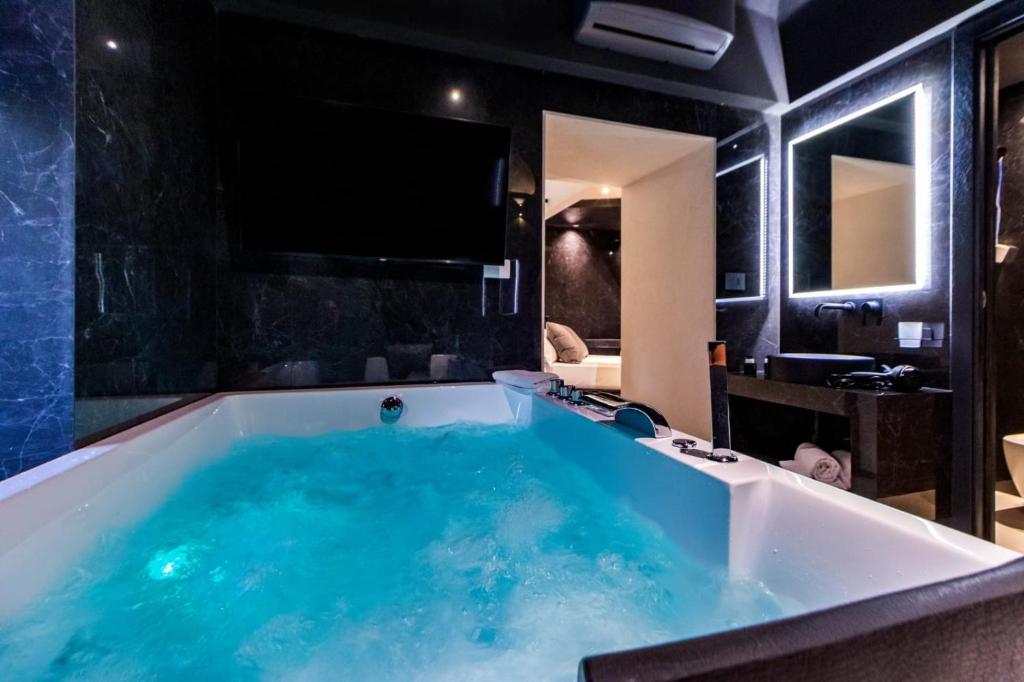 a large tub in a bathroom with a tv at 4 Suites " unconventional living rooms " in Catania