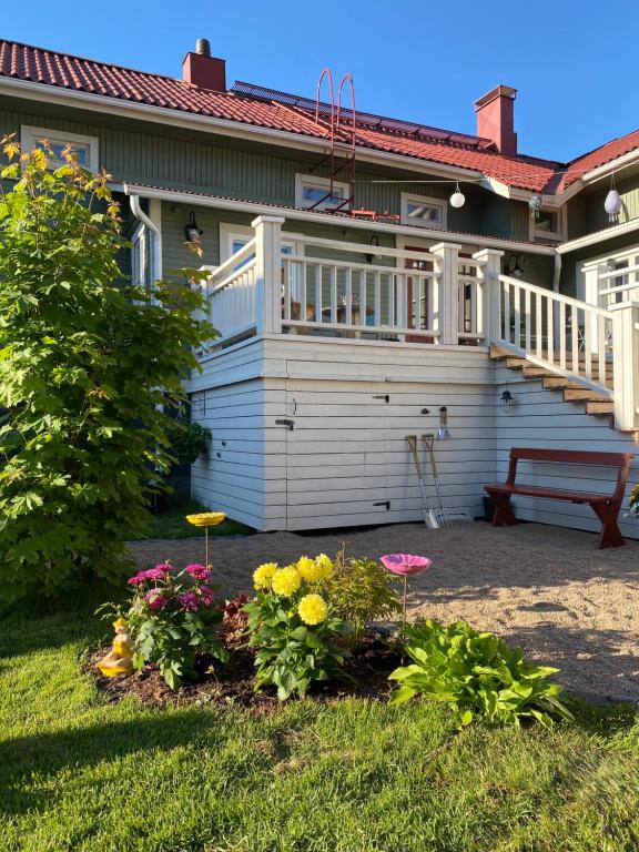 a house with a porch and flowers in the yard at Eleonora Bed & Breakfast in Kristiinankaupunki