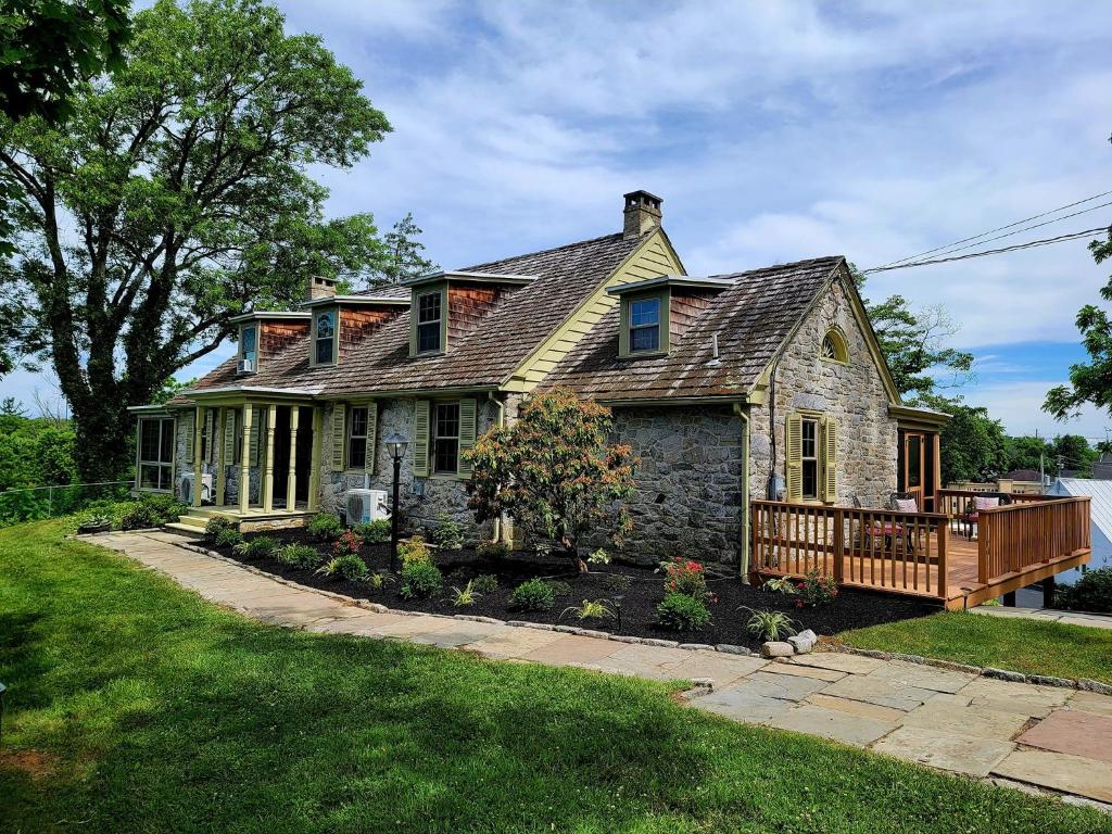 ダウニングタウンにあるDowningtown Manor - 1900s Farmhouse with Creek Viewsの古石造りの家(ポーチ付)