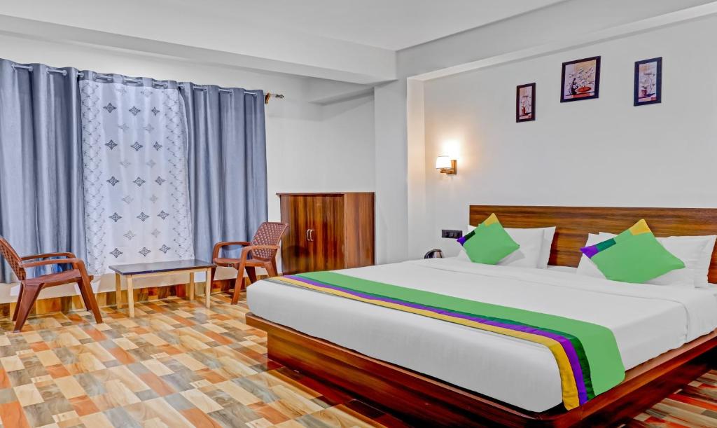 a bedroom with a large bed and two chairs at The Royale Crest in Gangtok