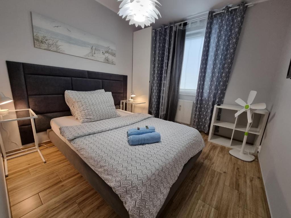 ein Schlafzimmer mit einem Bett mit einem blauen Koffer drauf in der Unterkunft Apartament Calamo Tuwima Park in Olsztyn