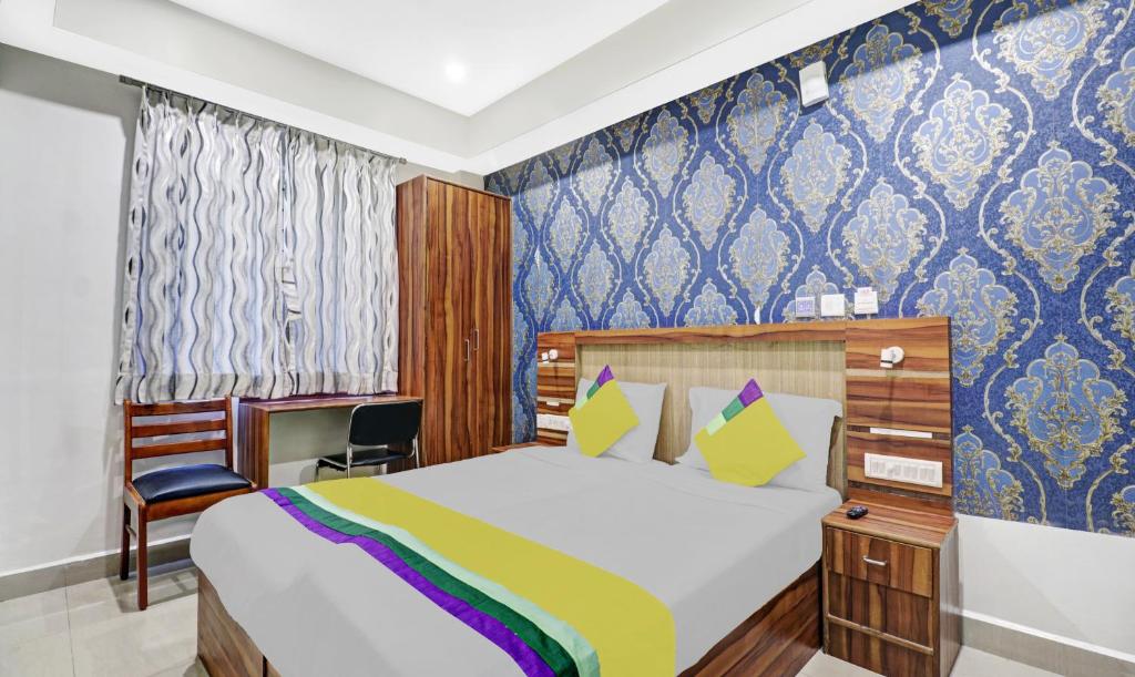 - une chambre avec un lit et une chaise dans l'établissement Itsy By Treebo - Elmas Golden Key, à Bangalore